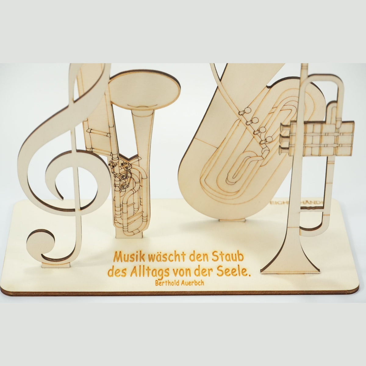 Detailaufnahme des Holz-Musikinstrumente-Geldgeschenks mit Gravur „Musik wäscht den Staub des Alltags von der Seele"